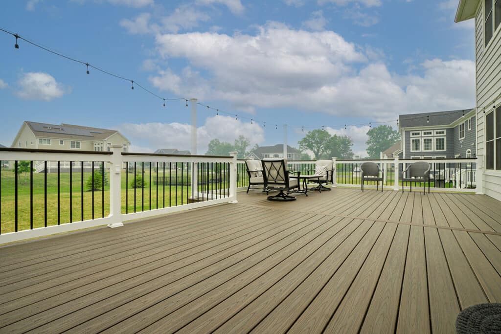 L-Shaped Composite Deck With Vinyl Railings And Tall Railings Post For Bistro Lights