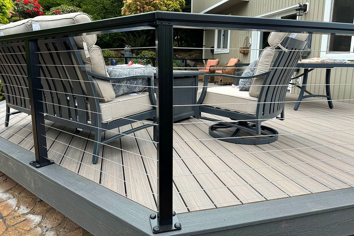 Low-Profile Horizontal Cable Deck Railing Enclosing Outdoor Patio Furniture On Composite Decking.