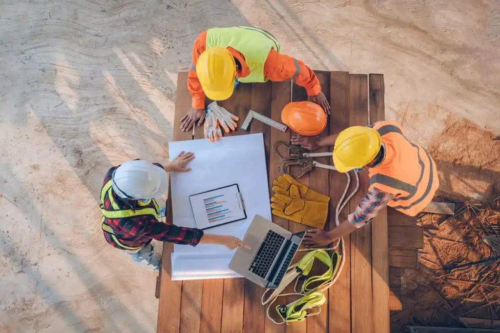 Construction team reviewing blueprints and planning their next steps for a project near trex deck builders near me