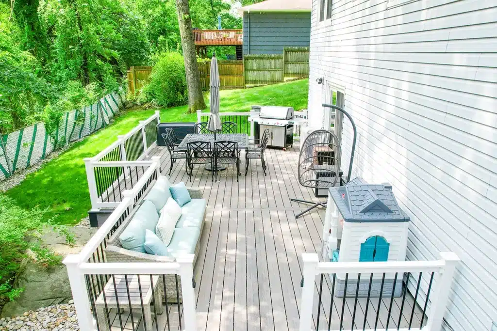A freshly resurfaced deck with modern railings, dining area, and cozy seating, perfect for deck resurfacing ideas.