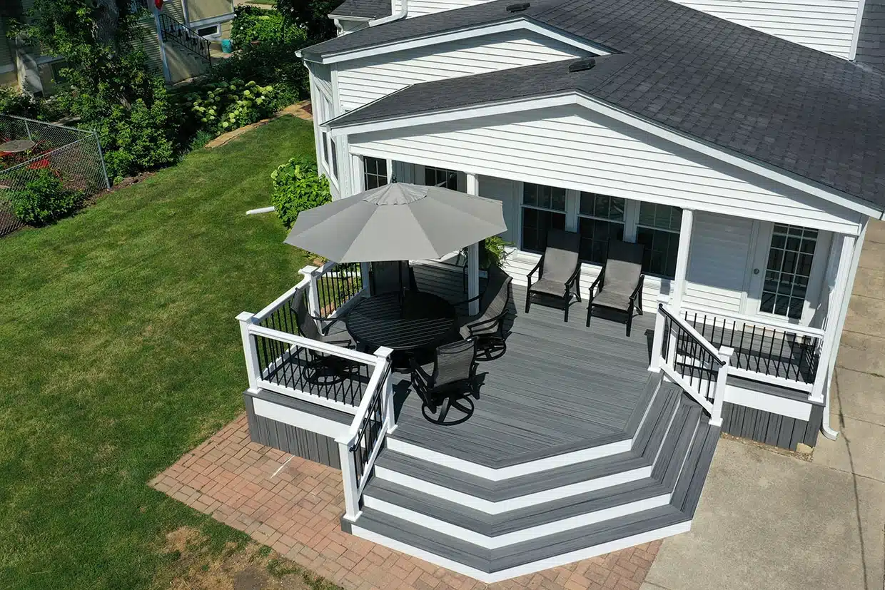 NJ Patio Installation 3 A Modern Deck With Seating And An Umbrella, Perfect For Nj Patio Installation.