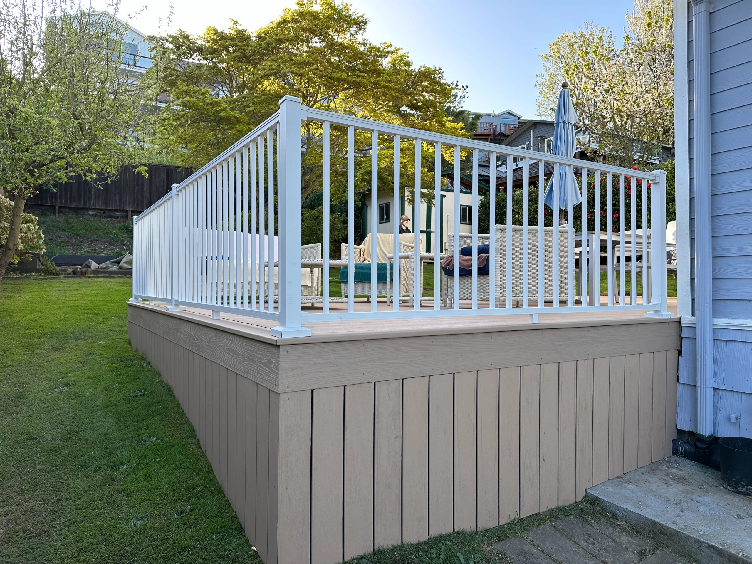 decking and railing 2 Clean White Railing With Decking In A Sunny Backyard, Showcasing Decking And Railing In A Peaceful Outdoor Setting.