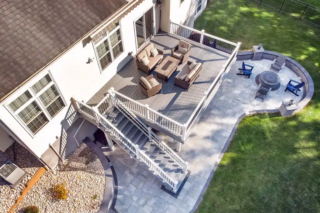 A spacious two-level deck featuring a seating area and fire pit, ideal for relaxation. Best patio materials for NJ ensure long-lasting durability.