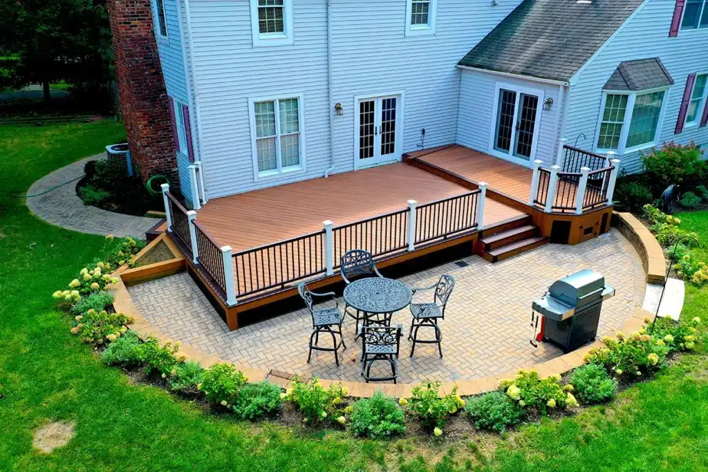 Backyard deck with railing, paver patio, grill, and seating for patio upgrades NJ.