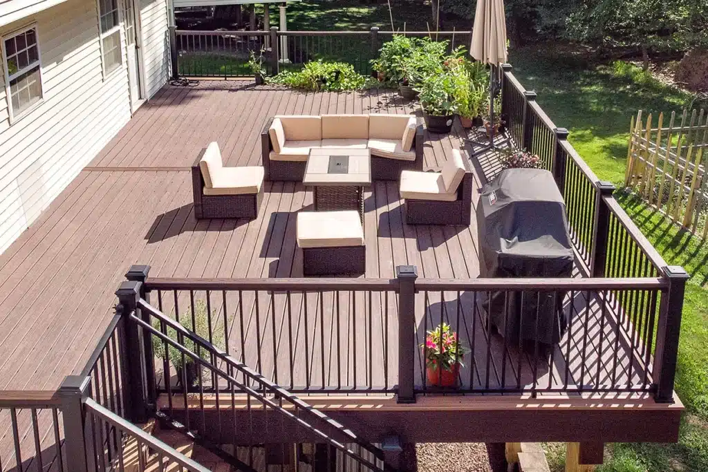 A spacious deck with comfortable seating and black railings, perfect for outdoor gatherings. The deck looks refreshed and safe, highlighting the benefits of NJ deck resurfacing vs replacement.