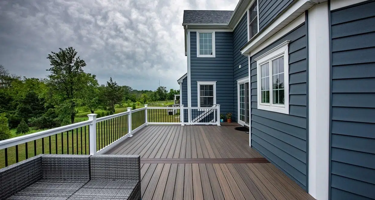 Second-Floor Composite Deck In Robbinsville, Nj With Vinyl Railings, Stairs To The Ground, And A Spacious Outdoor Living Area.